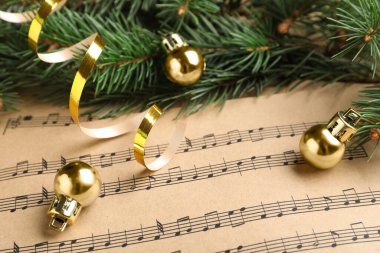 Firavun dalları, altın flamalar ve toplar Noel müzik sayfalarında, yakın plan
