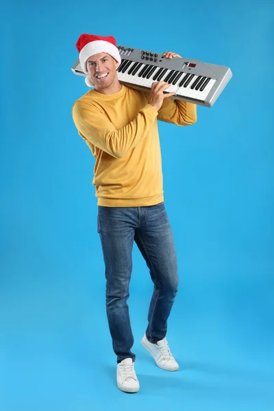 Man Santa Hat Playing Synthesizer Light Blue Background Christmas Music — Stock Photo, Image