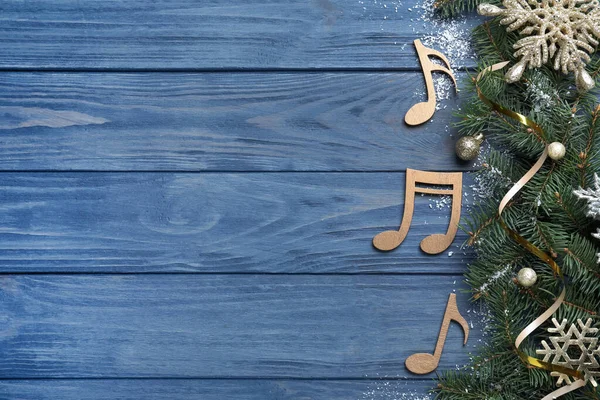 枞树枝条 装饰着圣诞装饰 靠近装饰的乐谱和蓝色木制背景的文字空间 平坦的地面 — 图库照片