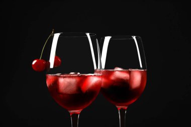 Lezzetli kiraz şarabı ve siyah arka planda sulu böğürtlenler, yakın plan