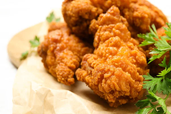 Tasty deep fried chicken pieces served on table, closeup