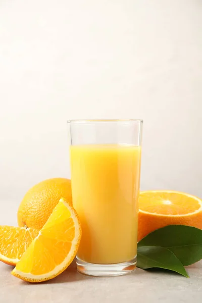 Smaklig Apelsinjuice Färska Frukter Och Gröna Blad Ljust Bord — Stockfoto