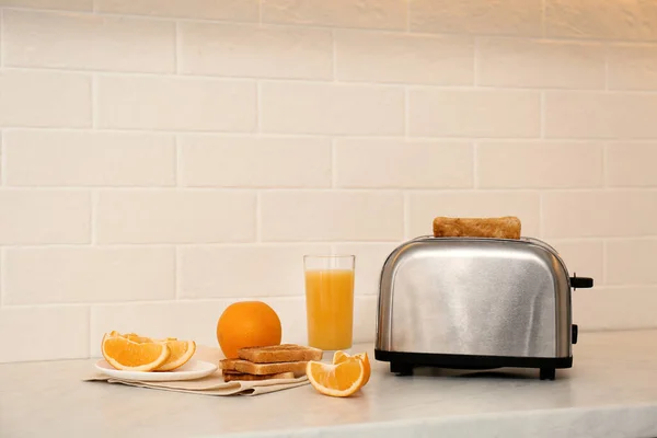 现代烤面包机和美味的早餐放在厨房的柜台上 — 图库照片
