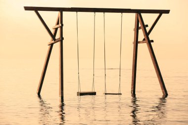 Gün doğumunda suda salıncak manzarası