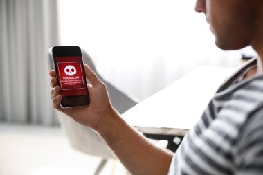 Elinde akıllı telefon taşıyan bir adam virüs saldırısı ihbarında bulundu.