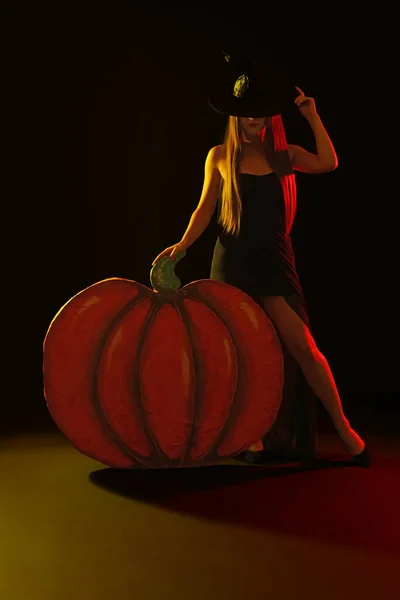 Fiatal Boszorkányjelmezt Visel Dekoratív Tök Közelében Fekete Háttérrel Halloween Buli — Stock Fotó