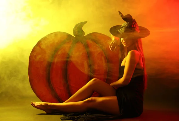 Egy Fiatal Boszorkányjelmezt Visel Dekoratív Tök Közelében Füstfelhőben Halloween Buli — Stock Fotó