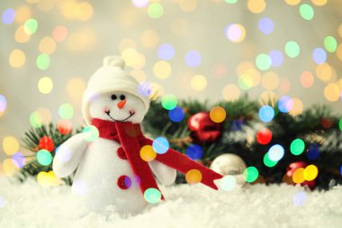Tatlı kardan adam ve köknar ağacı dalları. Kar üzerinde Noel topları, bokeh etkisi. Metin için boşluk
