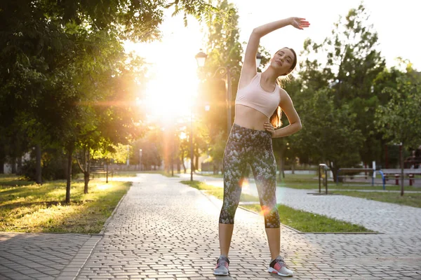 公園を走る前に若い女性が伸びている テキストのスペース — ストック写真