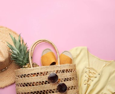 Pembe arka planda kamış çantalı düz kompozisyon.