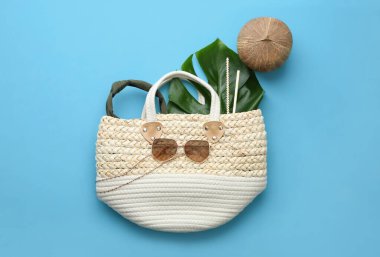 Düz kompozisyon, açık mavi arka planda kadın saman torbası.