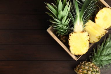Tahta masadaki sandıktaki ananas dilimleri düzdü. Metin için boşluk