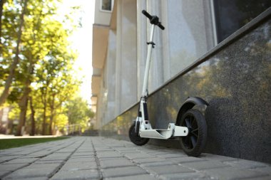 Binanın yakınına park edilmiş modern elektrikli scooter. Metin için boşluk