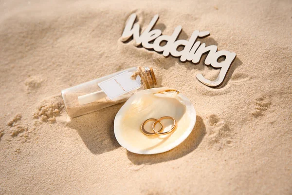 Раковина Золотыми Кольцами Приглашение Стеклянной Бутылке Слово Свадьба Песчаном Пляже — стоковое фото
