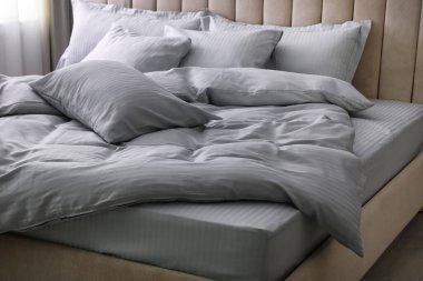 Yumuşak battaniyeli ve yastıklı rahat bir yatak.