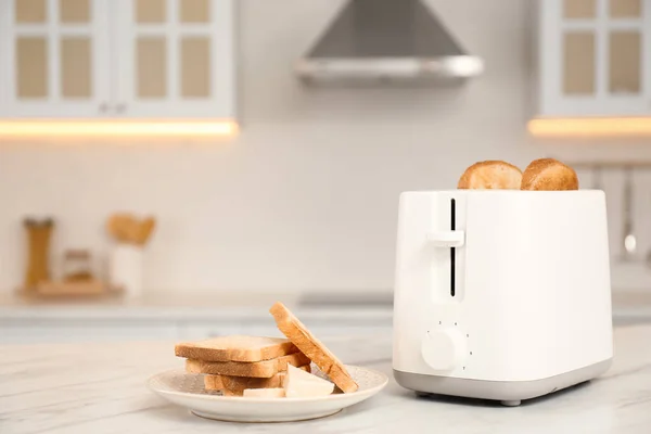 厨房白色大理石桌上的现代烤面包机和面包片 — 图库照片