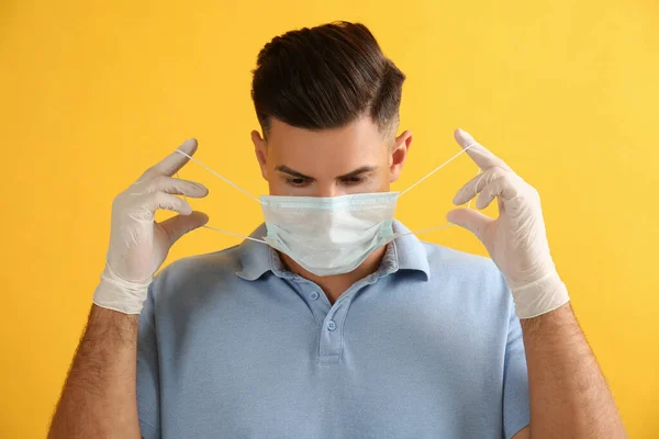 Άντρας Ιατρικά Γάντια Που Φοράει Προστατευτική Μάσκα Προσώπου Κίτρινο Φόντο — Φωτογραφία Αρχείου