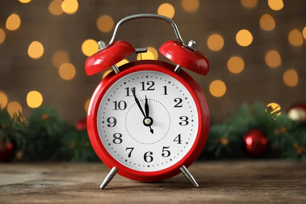 ぼやけたクリスマスライトに対して木製のテーブルの上に装飾が施された目覚まし時計 閉じます 新年のカウントダウン — ストック写真