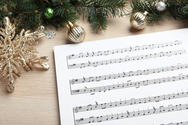 Composition with Christmas music sheets on wooden background, closeup