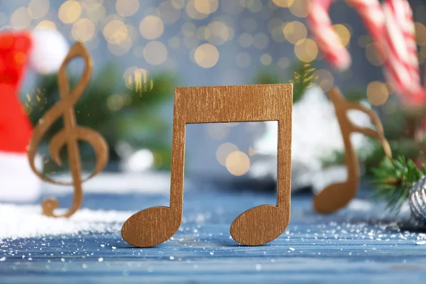 Açık Mavi Masadaki Ahşap Müzik Notası Bulanık Noel Işıklarına Karşı — Stok fotoğraf