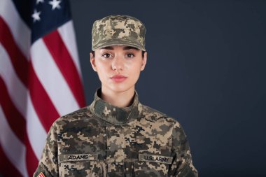 Koyu arkaplanda Amerikan askeri ve bayrağı var. Askerlik.
