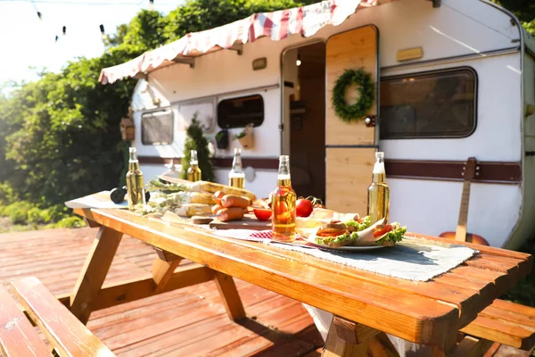 Holztisch Mit Essen Und Bierflaschen Neben Anhänger Sonnigem Tag Campingsaison — Stockfoto