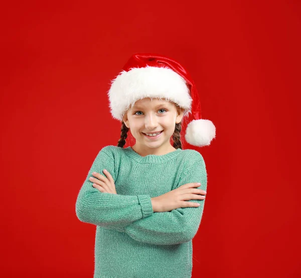 赤い背景にサンタの帽子の幸せな小さな子供 クリスマスのお祝い — ストック写真