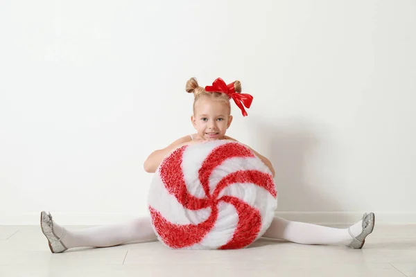 Симпатична Маленька Дівчинка Одягнена Цукерки Сидить Біля Білої Стіни Різдвяний — стокове фото