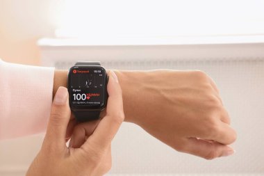 MYKOLAIV, UKRAINE - 19 Eylül 2019: Elma Saati olan kadın kalp atışlarını kontrol ediyor, yakın çekim