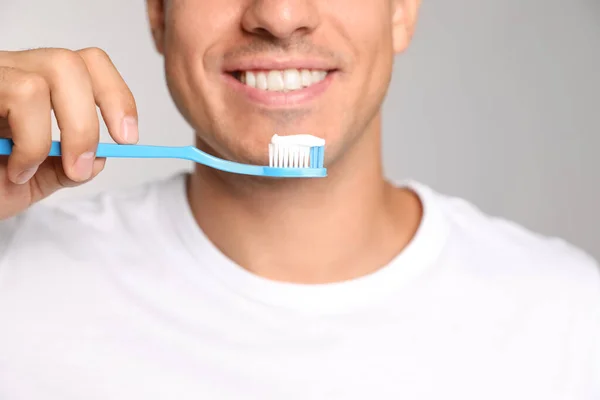 Man Holding Toothbrush Paste Light Background Closeup — Stock Photo, Image