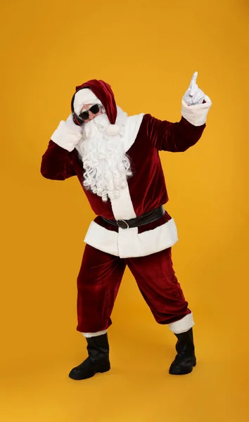 Kulaklıklı Noel Baba Sarı Arka Planda Noel Müziği Dinliyor — Stok fotoğraf