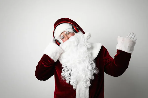 Weihnachtsmann Mit Kopfhörer Hört Weihnachtsmusik Auf Hellem Hintergrund — Stockfoto