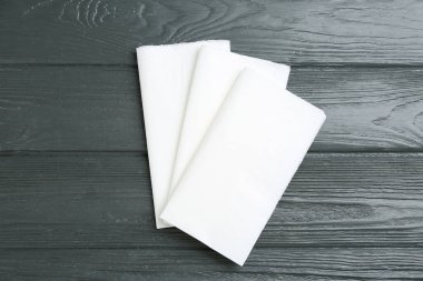 Gri ahşap masada temiz peçeteler, düz yatıyordu.