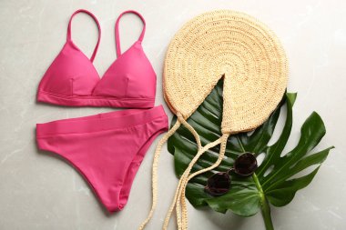 Güzel pembe bikini ve plaj aksesuarları açık mermer arka planda, düz yerde