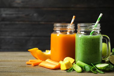 Lezzetli sebze suları ve ahşap masada taze malzemeler. Metin için boşluk