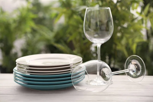 背景がぼやけている白いテーブルの上にきれいな食器とワイングラスのセット — ストック写真