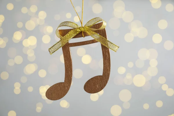 带有金弓的木制乐谱挂在淡灰色背景上 圣诞灯火通明 — 图库照片