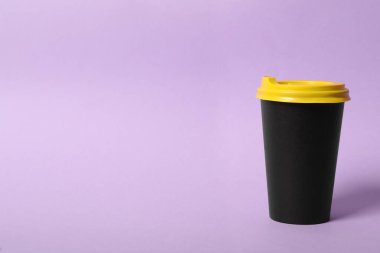 Menekşe arka planda paket kağıttan kahve fincanı. Metin için boşluk