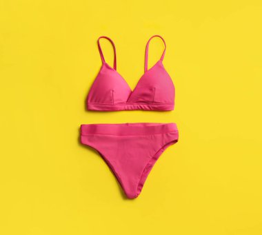 Sarı arka planda güzel pembe bikini, üst manzara.