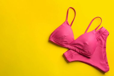 Sarı arka planda güzel pembe bikini, üst manzara. Metin için boşluk