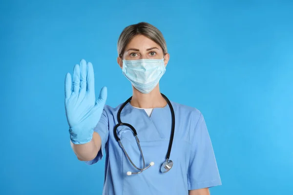 Docteur Masque Protection Montrant Geste Arrêt Sur Fond Bleu Clair — Photo