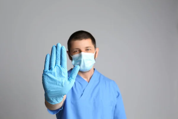 Dottore Maschera Protettiva Mostrando Gesto Arresto Sfondo Grigio Prevenire Diffusione — Foto Stock