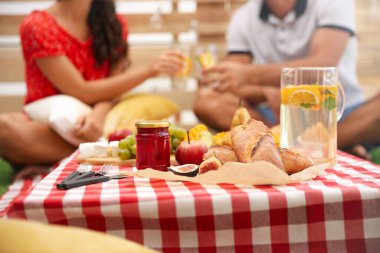 Evde piknik yapan çiftler, lezzetli yemeklere odaklanırlar.