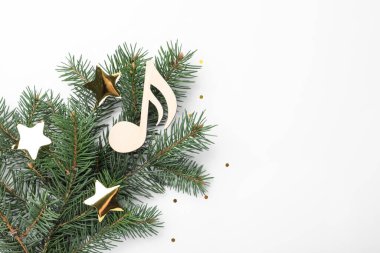 Dekoratif altın yıldızlı firavun ağacı dalı ve beyaz arka planda ahşap müzik notası, üst manzara. Noel kutlaması