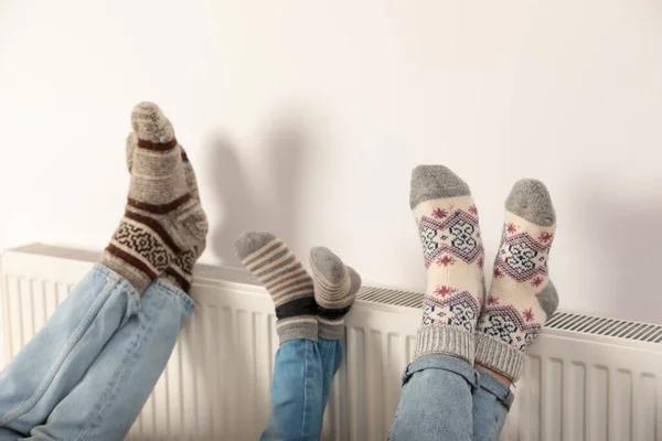 Familie Wärmt Beine Auf Heizkörper Der Nähe Der Weißen Wand — Stockfoto