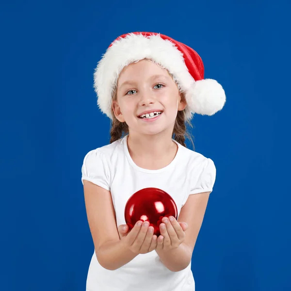 Criança Feliz Santa Chapéu Segurando Bola Natal Fundo Azul — Fotografia de Stock