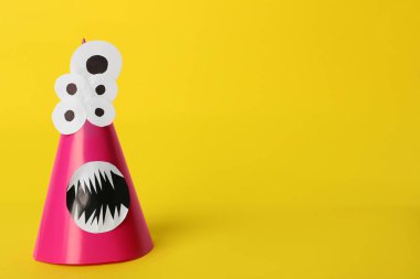 Sarı arka planda komik pembe canavar, mesaj için yer var. Cadılar Bayramı dekorasyonu