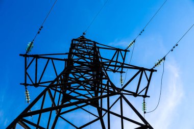 Güzel mavi gökyüzüne karşı yüksek voltaj kulesi, alçak açı