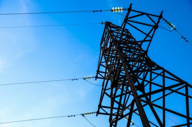 Güzel mavi gökyüzüne karşı yüksek voltaj kulesi, alçak açı