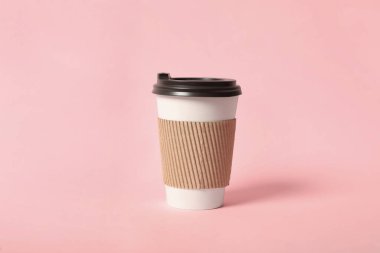 Pembe arka planda karton kollu paket kâğıt kahve fincanı.